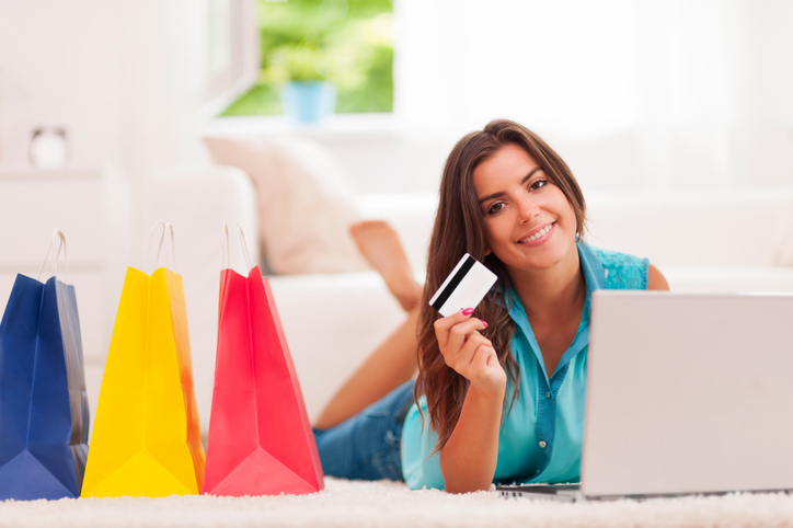 Beautiful woman paying by credit card for shopping at home