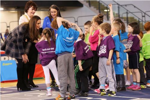 Kate Middleton sul campo da basket con cappottino e stivali